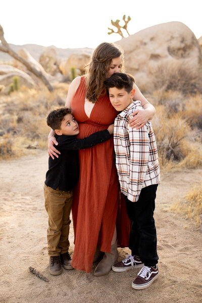Mother and sons hugging in Joshua Tree National Park.