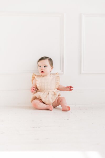 Baby girl sits up in studio during her milestone session in charlotte nc