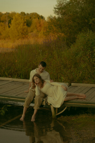 Man and woman romantically spin around, laughing in the middle of a  flowery field