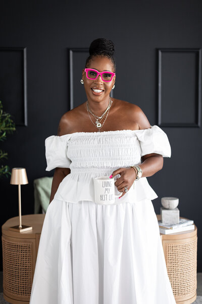 A woman is wearing a white dress and pink glasses