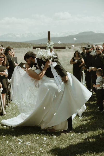 Bride and groom kiss in the aisle after their mountain wedding ceremony