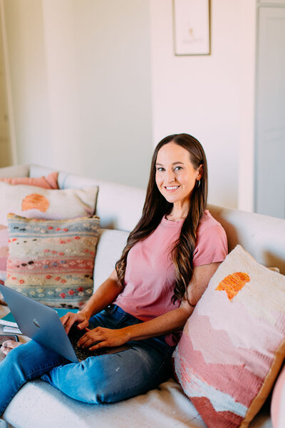 Woman sitting on the couch working on a laptop