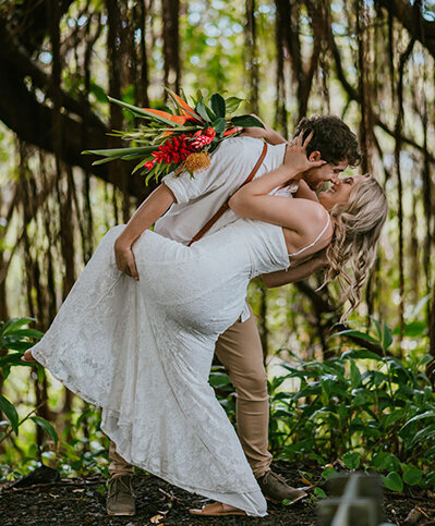 bride and groom dip kiss in jungle