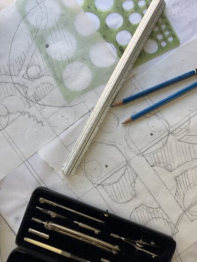close up of drafting paper, protractor, pencils, and ruler for garden sketch