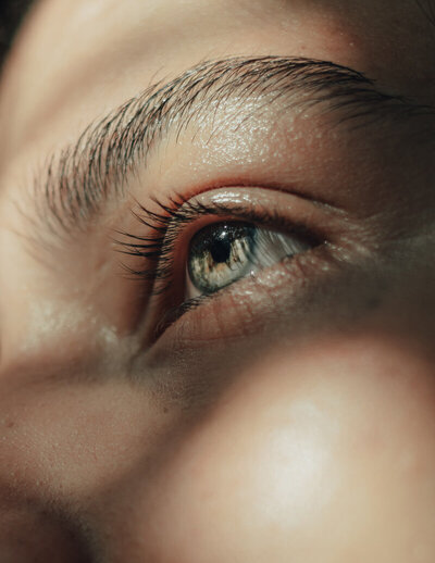 Gros plan sur l'oeil d'une femme, pupille couleur verte.