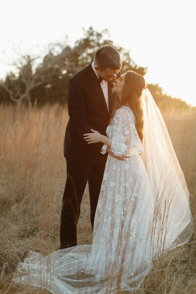 wedding couple standing in tall grass during Texas wedding