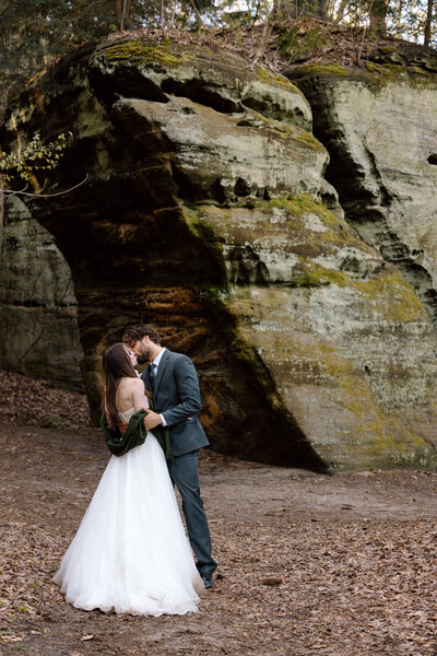 Bride and groom kissing near rock formations at Ledges trail in Cuyahoga Valley National Park.