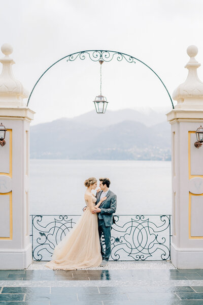 Bride and groom post at Lake Como for their destination wedding.