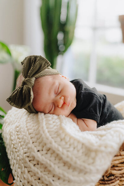 Newborn baby asleep resting head on a blanket