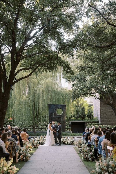 Art museum wedding ceremony in front of sculpture