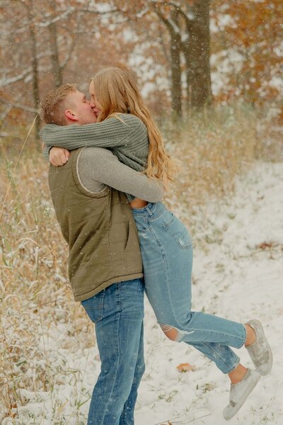 Couple kissing at outdoor photoshoot during autumn