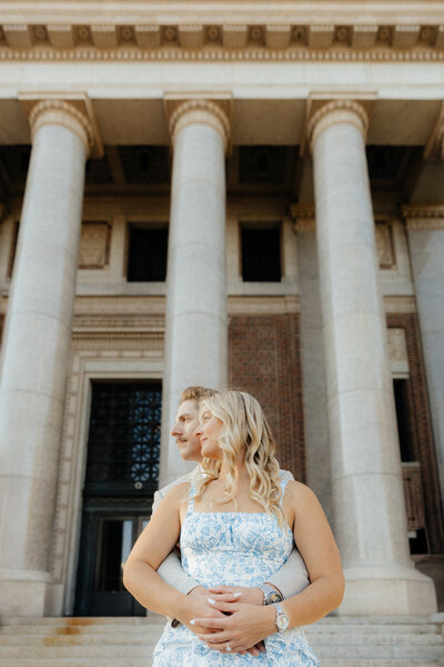 A couple standing in front of a courthouse during their portrait session.