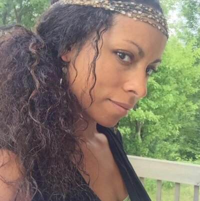 Dr. Ida B softly smiling outdoors