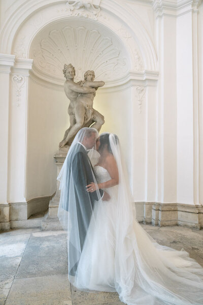 Destination Wedding couple kissing in the halls of luxury palace Daun Kinsky in Vienna executed by ECLAT Destination Weddings