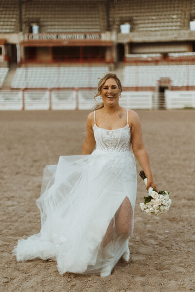 bride laughing at rodeo with cowboy boots on