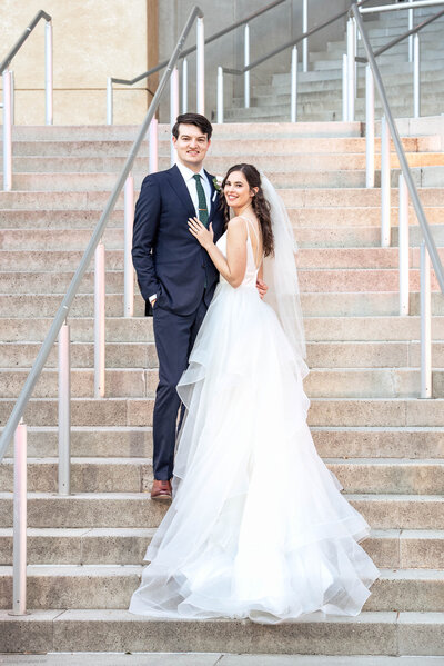 Bride and groom on steps of the Mint Museum Uptown by Charlotte wedding photographers DeLong Photography