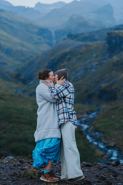 Two wives kiss with their hands on each others' faces during their LGBTQ Iceland elopement