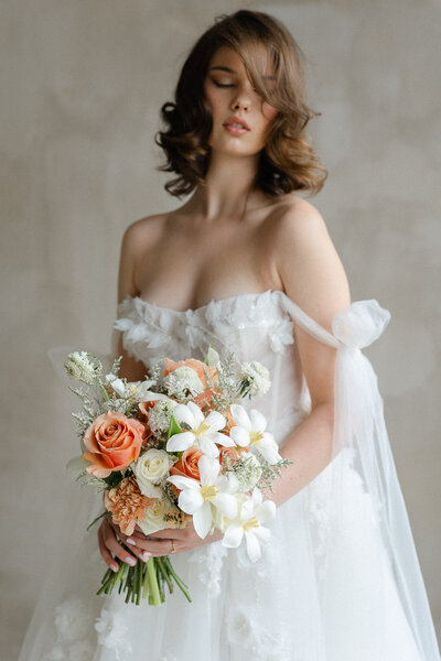 Mariee qui tient un magnifique bouquet de fleurs roses et blanches