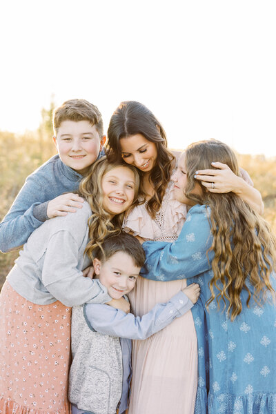 Mom having a group hug with her four kids