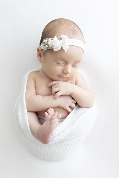 baby girl swaddled in white wrap