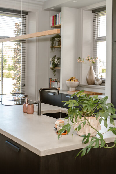 Strakke televisiewand met een wit zwevend meubel, subtiele decoratie en warme verlichting, een ontwerp van LOOSZ.