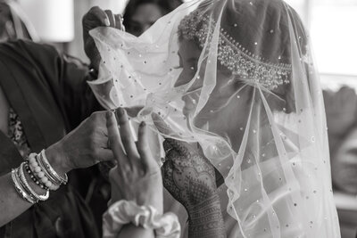 Bride brushing her lipstick off the groom's lips after giving him a kiss during their first look