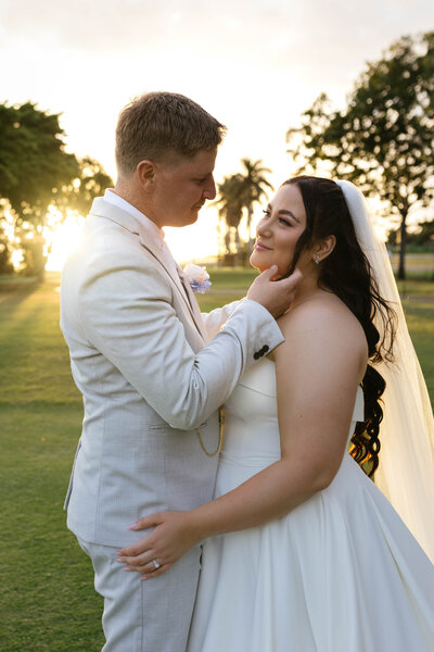 A couple shares an intimate sunset moment on a golf course, lovingly holding each other as they gaze into each other’s eyes – captured by a Bendigo Wedding photographer.