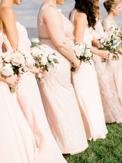 Soft blush bridesmaids dresses at waterfront ceremony