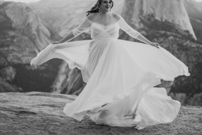 black adn white of bride twirling in wedding dress
