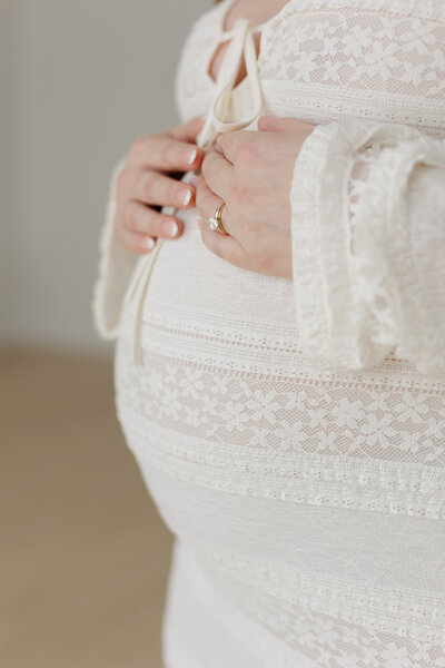 Pregnant mom holding her belly in a close up photo 
