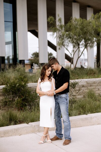 couple embraced engaement photo with white pillars in the background