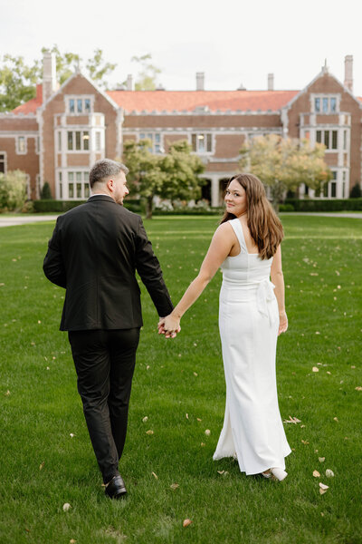 a couple walking together towards the mansion at Waveny park