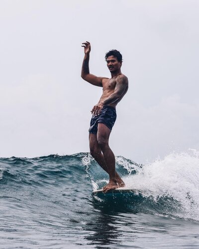 Man noseriding at longboarding retreat in Indonesia