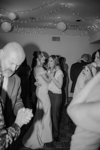 two brides dance together at wedding reception indoors