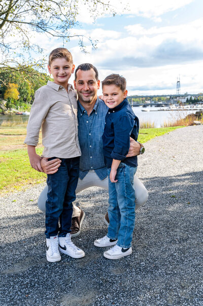 Father kneeling down with this two toddler sons in Westport, CT.