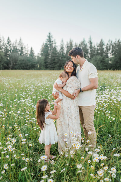 Family in a flower field, mother holding a baby