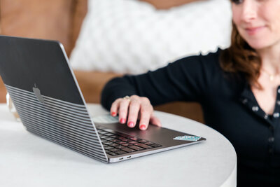 laptop of showit designer on kitchen island next to a coffee mug