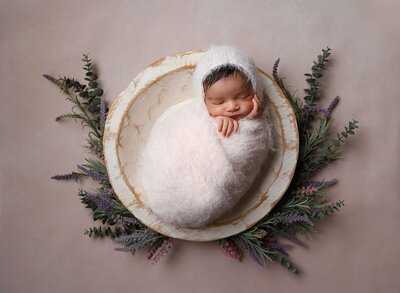 Days-old newborn baby wrapped in pink fabric by SLC newborn photographer, Diane Owen