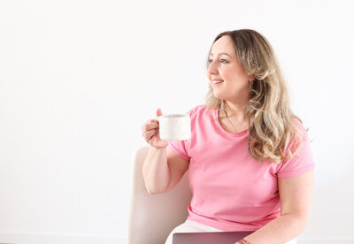 ontwerper in roze t-shirt met koffie in haar hand