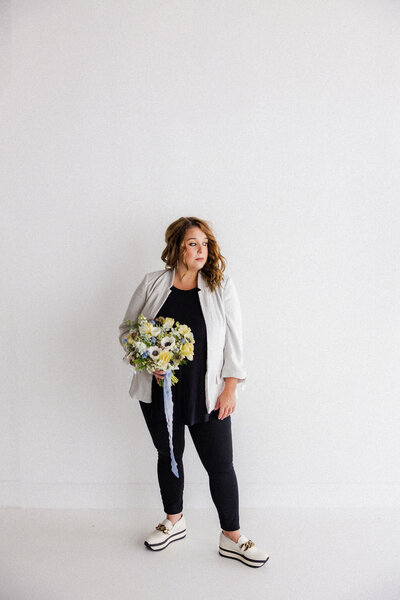 Professional portrait of The Eventful Gals founder holding a seasonal bouquet, representing elevated wedding planning services in St. Augustine and beyond.
