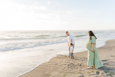 pregnant mom in green poses with family 