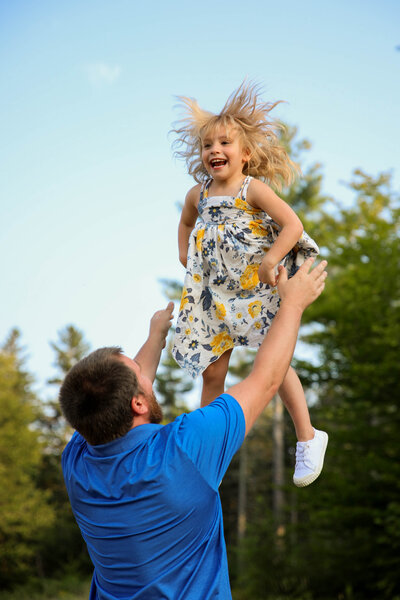 Father playing with daughter, throwing her up in air | Family Photography Session