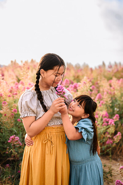 2 sisters holding a purple flower in a wildflower field near martinez