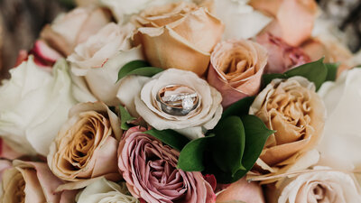 bride and groom's wedding rings photographed in the bride's bouquet