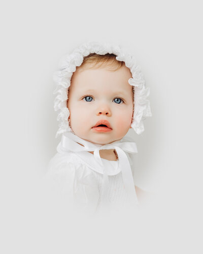 Baby girl with blue eyes stares into camera during portrait session in Raleigh NC