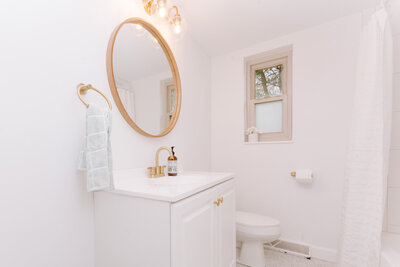 all white bathroom with gold finishes