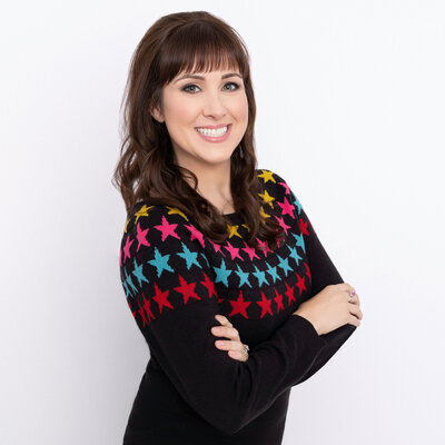 Headshot of Brittany Hodak, customer experience expert. She wears a black sweater with colorful stars.