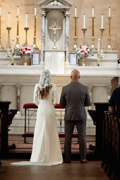 A couple stands at the altar of St. Mary's catholic church in Nashville, tennessee during their catholic wedding Mass