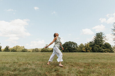 Elizabeth running in field with arms open