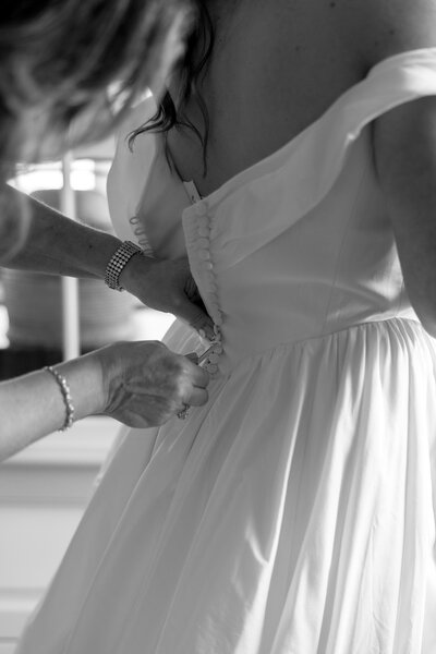 Couple wearing wedding attire and holding white flowers standing at steps in city hall